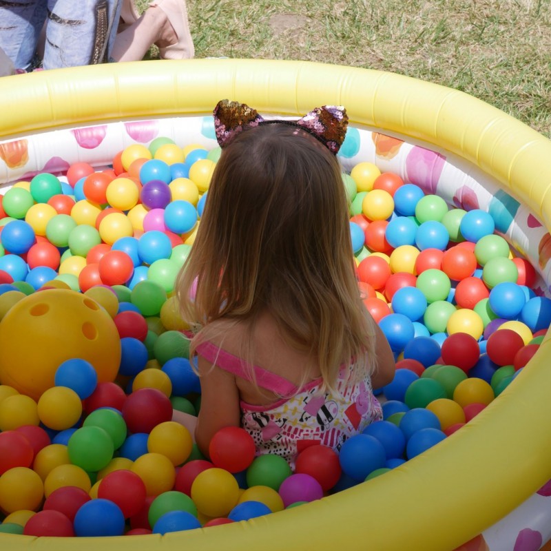 Mała dziewczynka bawi się w baseniku z kolorowymi, plastikowymi kulkami.