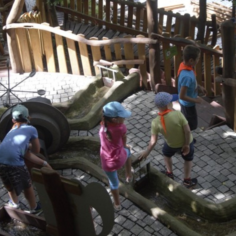 Dzieci oglądają skonstruowane rzeki z ruchomymi tamami.