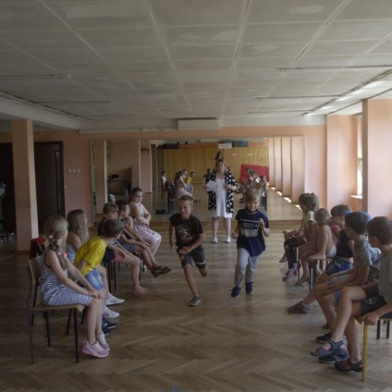 Grupa dzieci bawi się podczas zajęć w sali z lustrami.