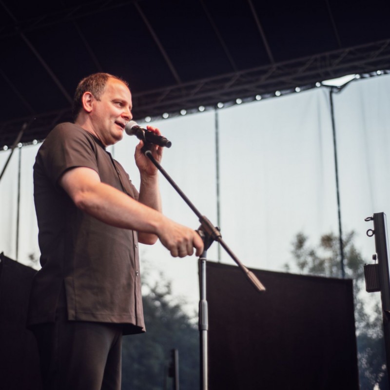 Fot. Łukasz Kuc/Ireneusz Krosny mówiący do mikrofonu podczas występu na scenie.
