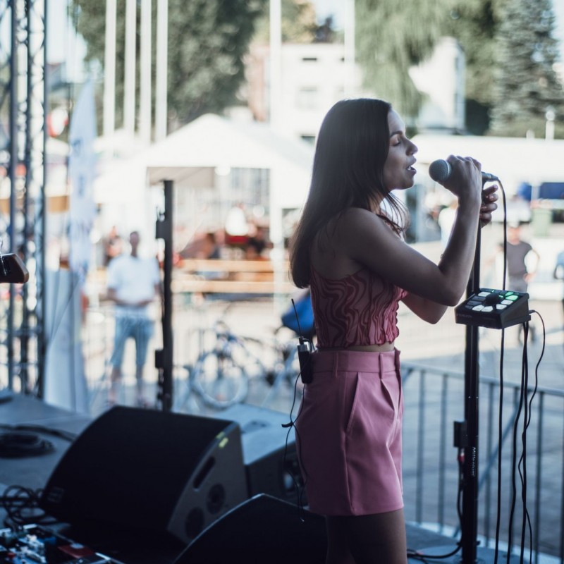 Fot. Łukasz Kuc/Dziewczyna śpiewa do publiczności na scenie plenerowej.